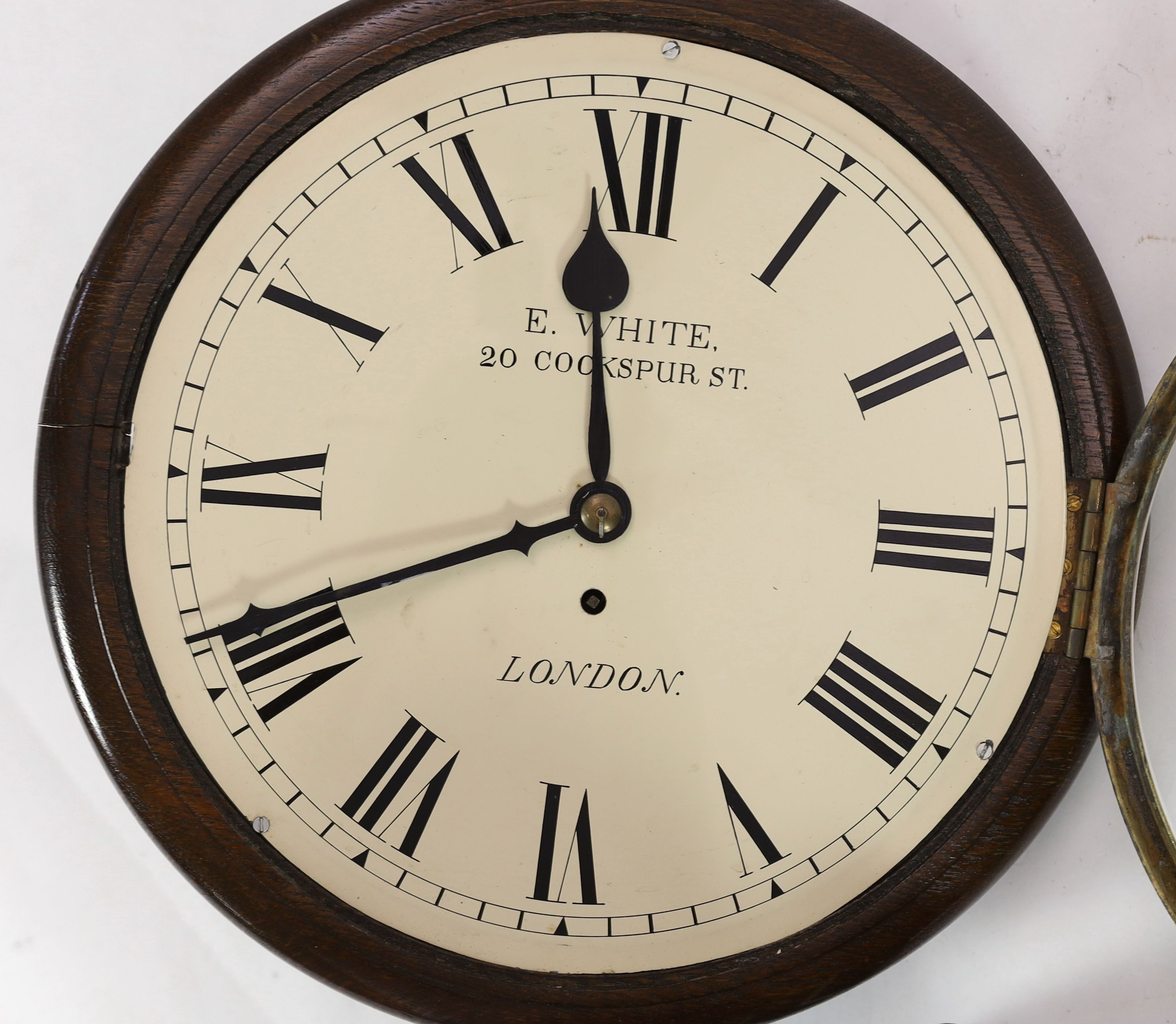 E. White, 20 Cockspur Street, London. A late Victorian oak cased wall timepiece, diameter 38cm